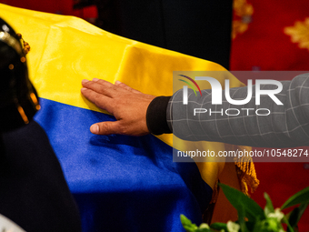 A men touches the coffin of the late Colombian artist Fernando Botero who lies inside the National Congress during his wake in Bogota, Colom...