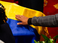 A men touches the coffin of the late Colombian artist Fernando Botero who lies inside the National Congress during his wake in Bogota, Colom...