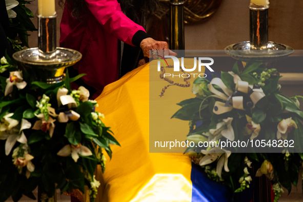 A person knocks on the coffin of the late Colombian artist Fernando Botero lies inside the National Congress during his wake in Bogota, Colo...