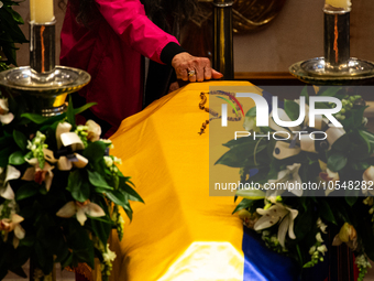 A person knocks on the coffin of the late Colombian artist Fernando Botero lies inside the National Congress during his wake in Bogota, Colo...