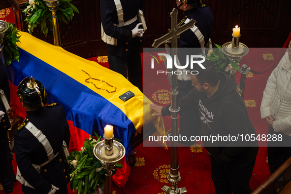 People pass to pay respects as the late Colombian artist Fernando Botero lies inside the National Congress during his wake in Bogota, Colomb...