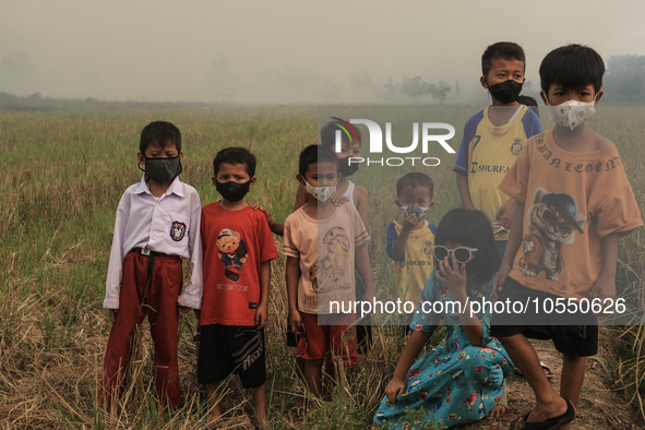 Children in Soak Batok Village, North Indralaya District, Ogan Ilir Regency, South Sumatra are wearing masks to avoid bad air caused by fore...