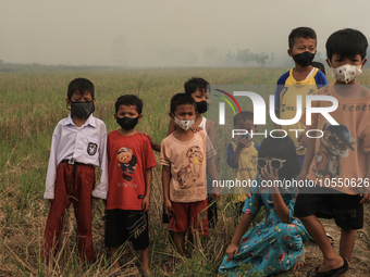 Children in Soak Batok Village, North Indralaya District, Ogan Ilir Regency, South Sumatra are wearing masks to avoid bad air caused by fore...