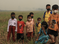 Children in Soak Batok Village, North Indralaya District, Ogan Ilir Regency, South Sumatra are wearing masks to avoid bad air caused by fore...