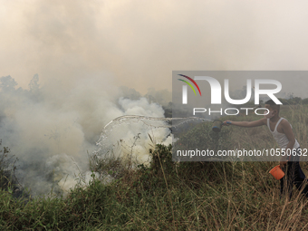 A small child in Soak Batok Village, North Indralaya District, Ogan Ilir Regency, South Sumatra is extinguishing forest and land fires on Mo...