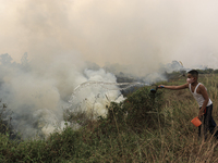 A small child in Soak Batok Village, North Indralaya District, Ogan Ilir Regency, South Sumatra is extinguishing forest and land fires on Mo...