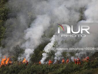 CHENGDE, CHINA - SEPTEMBER 25, 2023 - Firefighters perform a fire fighting drill in a forest area in Chengde, Hebei Province, China, Sept 25...