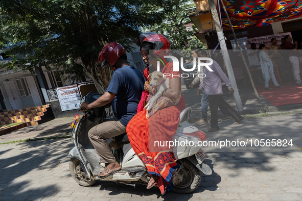 Man and woman returns with their dog on scooter after administer Anti-Rabies Vaccine (ARV) at a Govt. veterinary hospital, during a free ant...