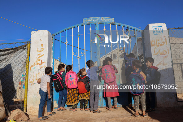 Photos taken on September 30, 2023, show Syrian students attending the first day of the new school year at a makeshift school inside a camp...