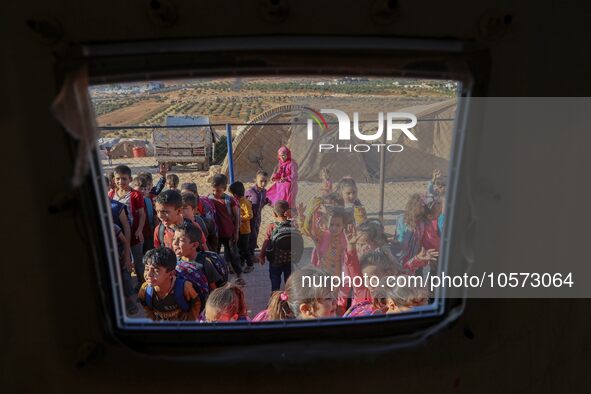 Photos taken on September 30, 2023, show Syrian students attending the first day of the new school year at a makeshift school inside a camp...