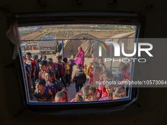 Photos taken on September 30, 2023, show Syrian students attending the first day of the new school year at a makeshift school inside a camp...