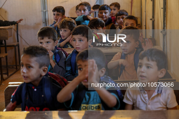 Photos taken on September 30, 2023, show Syrian students attending the first day of the new school year at a makeshift school inside a camp...