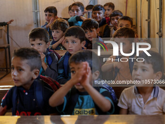 Photos taken on September 30, 2023, show Syrian students attending the first day of the new school year at a makeshift school inside a camp...