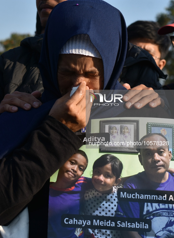 A mother cries
carrying  the photos of victim tragedy,  during praying to commemorate the 1st anniversary of the Kanjuruhan tragedy which 1...