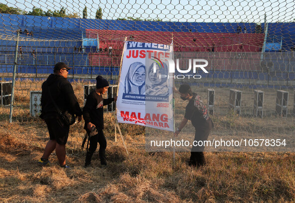 Supporters of Arema FC are putting up photos of the victims in the goal area of the field, during the first anniversary of the Kanjuruhan tr...