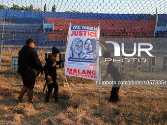 Supporters of Arema FC are putting up photos of the victims in the goal area of the field, during the first anniversary of the Kanjuruhan tr...