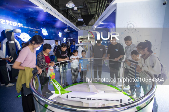 Children and parents look at the C919 model at the Taizhou Science and Technology Museum in Taizhou, east China's Jiangsu province, Oct 2, 2...