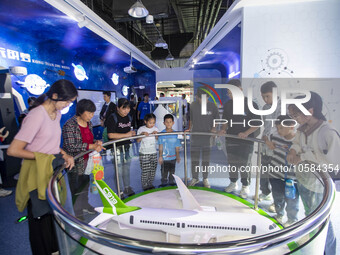 Children and parents look at the C919 model at the Taizhou Science and Technology Museum in Taizhou, east China's Jiangsu province, Oct 2, 2...