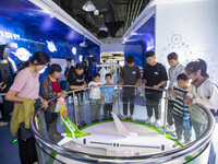 Children and parents look at the C919 model at the Taizhou Science and Technology Museum in Taizhou, east China's Jiangsu province, Oct 2, 2...