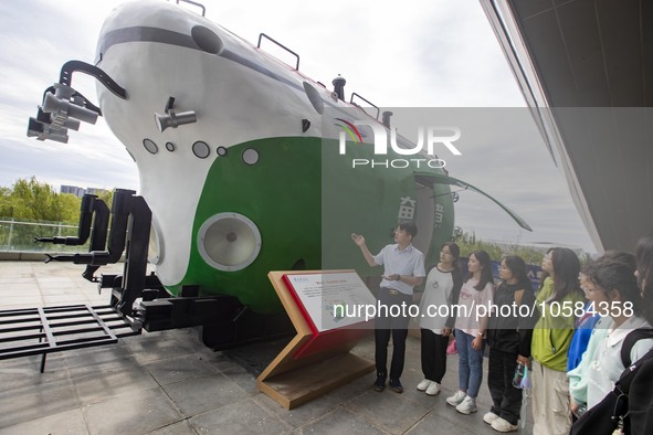 A staff member introduces a model of the ''Striver'' to students at the Taizhou Science and Technology Museum in Taizhou, Jiangsu province,...