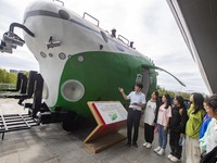 A staff member introduces a model of the ''Striver'' to students at the Taizhou Science and Technology Museum in Taizhou, Jiangsu province,...