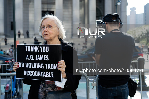 A woman holds a sign in support of A.G. Letitia James outside the New York Supreme Court where Donald Trump faces trial in a civic court cas...