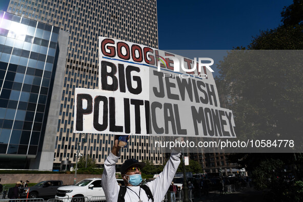 A man holds an antisemitic sign outside the New York Supreme Court where Donald Trump faces trial in a civic court case brought by New York...