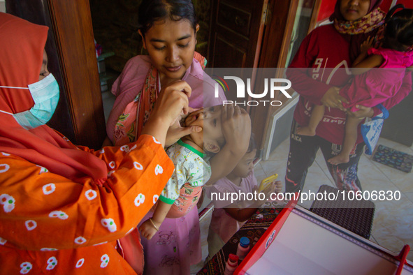 A baby receives a Vitamin A capsule during a child stunting prevention programme at an integrated services post (POSYANDU) in Kalongan Villa...