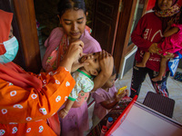 A baby receives a Vitamin A capsule during a child stunting prevention programme at an integrated services post (POSYANDU) in Kalongan Villa...