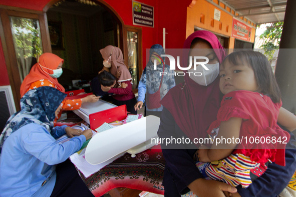 Health worker and volunteers checks several child before receiving a Vitamin A capsule during a child stunting prevention programme at an in...