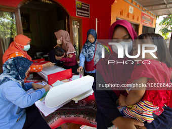 Health worker and volunteers checks several child before receiving a Vitamin A capsule during a child stunting prevention programme at an in...