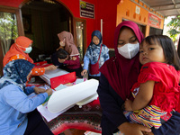 Health worker and volunteers checks several child before receiving a Vitamin A capsule during a child stunting prevention programme at an in...