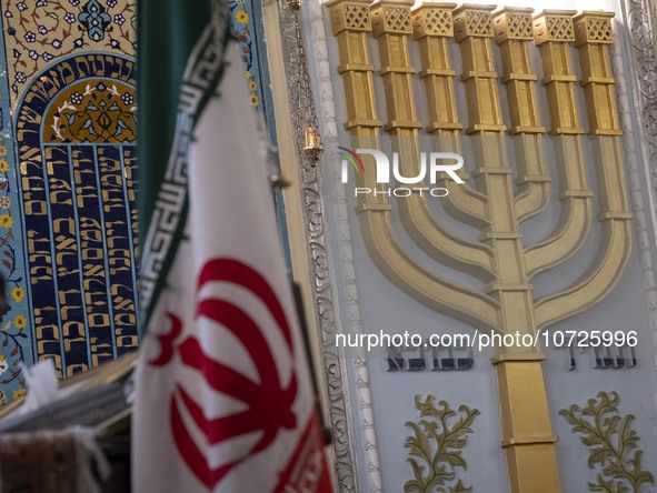 An Iranian flag is pictured alongside a Menorah (a Jewish symbol) during a gathering at a synagogue in downtown Tehran to protest against th...