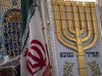 An Iranian flag is pictured alongside a Menorah (a Jewish symbol) during a gathering at a synagogue in downtown Tehran to protest against th...