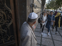 An Iranian-Jewish man calls for women to join a protest against Israeli attacks on Palestinian civilians held at a synagogue in downtown Teh...