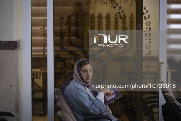 An Iranian-Jewish woman looks on as she reads a Hebrew Bible while sitting at a synagogue in downtown Tehran before a gathering to protest a...