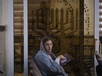 An Iranian-Jewish woman looks on as she reads a Hebrew Bible while sitting at a synagogue in downtown Tehran before a gathering to protest a...