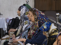 Iranian-Jewish women sit at a synagogue in downtown Tehran while taking part in a gathering to protest against Israeli attacks on Palestinia...