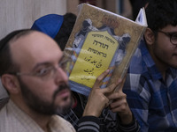 An Iranian-Jewish man reads a Hebrew Bible while sitting at a synagogue in downtown Tehran during a gathering to protest against Israeli att...