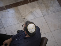 An Iranian-Jewish man sits at a synagogue in downtown Tehran during a gathering to protest against Israeli attacks on Palestinian civilians,...