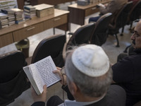 An Iranian-Jewish man reads a Hebrew Bible while sitting at a synagogue in downtown Tehran during a gathering to protest against Israeli att...