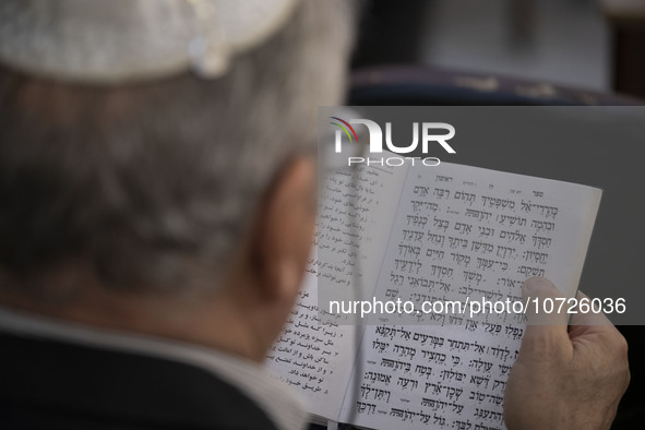 An Iranian-Jewish man reads a Hebrew Bible while sitting at a synagogue in downtown Tehran during a gathering to protest against Israeli att...