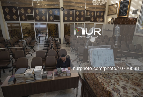 An Iranian-Jewish man reads a Hebrew Bible while sitting at a synagogue in downtown Tehran during a gathering to protest against Israeli att...