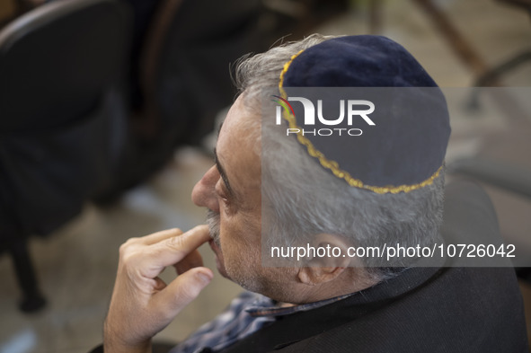 An Iranian-Jewish man sits at a synagogue in downtown Tehran during a gathering to protest against Israeli attacks on Palestinian civilians,...