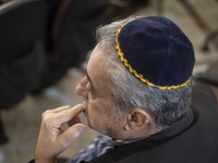 An Iranian-Jewish man sits at a synagogue in downtown Tehran during a gathering to protest against Israeli attacks on Palestinian civilians,...