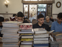 Young Iranian-Jewish men read Hebrew Bibles while sitting at a synagogue in downtown Tehran during a gathering to protest against Israeli at...