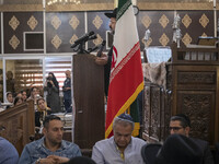 Rabbi Younes Hamami Lalehzar (top), Leader of Iranian Jews, delivers a speech as he stands next to an Iran flag at a synagogue in downtown T...