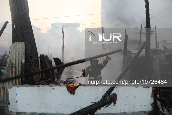 Fire service personnel from Bangladesh are currently clearing a burnt structure following a fire in Baburhat, Narsingdi, Bangladesh, on Octo...