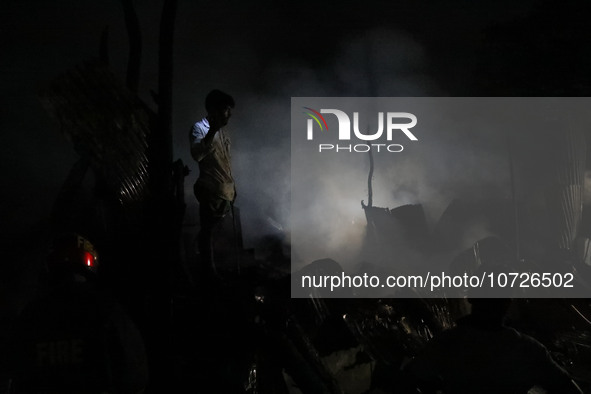 A trader is examining his burnt merchandise following a fire in Baburhat, Narsingdi, Bangladesh, on October 30, 2023. Currently, Baburhat is...