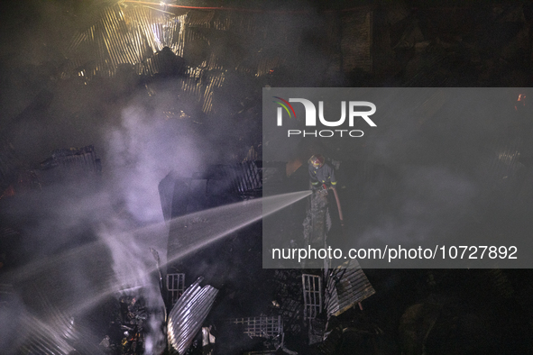 Bangladeshi fire fighters try to extinguish a fire that broke out Baburhat, Narsingdi on October 30, 2023, which is one of the biggest tradi...